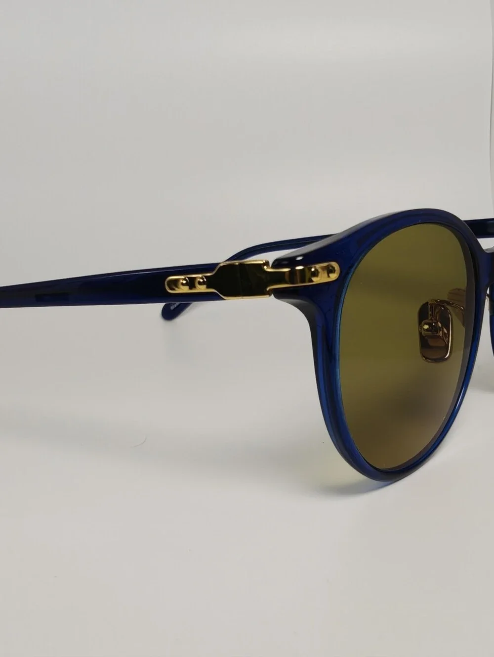 Dotti. Round Navy Translucent frame. Gold Hinge Extends to frame front.